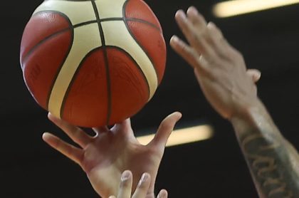 Manos sujetando balón de básquetbol