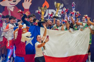 Grupo de jóvenes deportistas escolares sonriendo y posando para foto de conmemoración.